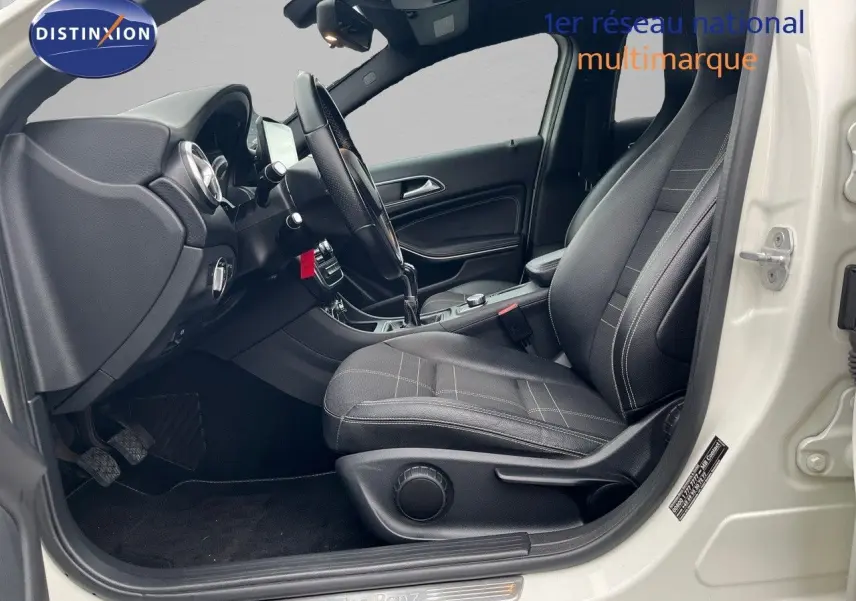 Intérieur côté conducteur d'une Mercedes Classe A 180 Sensation blanche de 2013, avec sièges noirs et boîte manuelle.