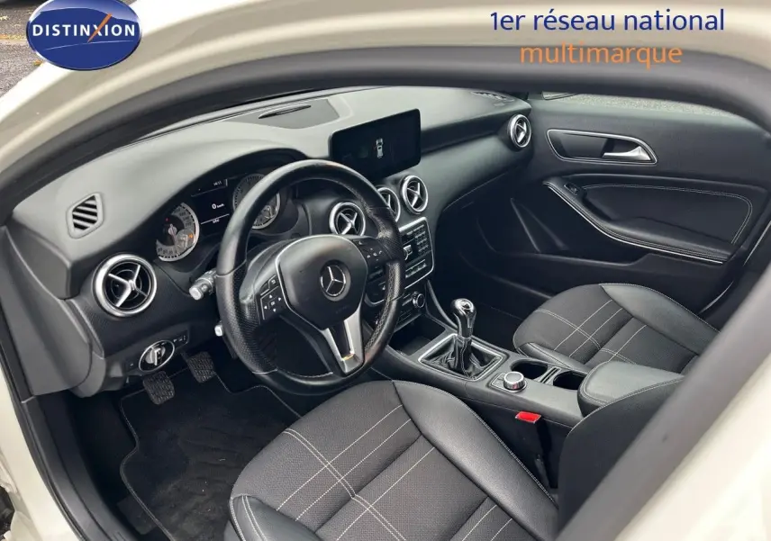 Intérieur noir de la Mercedes Classe A 180 Sensation 2013, vue côté conducteur avec volant et boîte manuelle visibles.