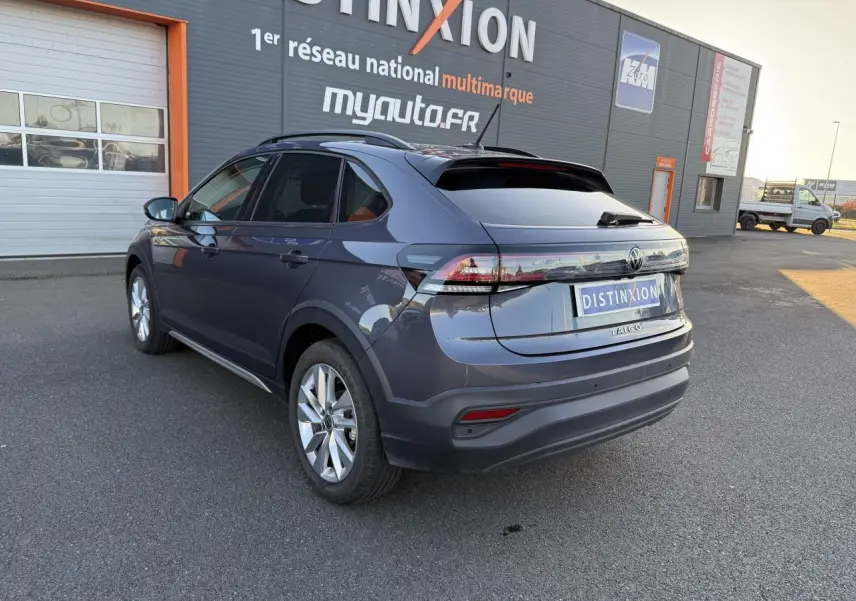 Vue 3/4 arrière droite d’un Volkswagen Taigo gris INC avec jantes alliage 17 pouces et vitres arrière surteintées.