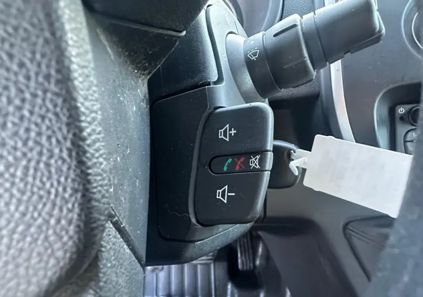 Gros plan sur les commandes au volant du Renault Kangoo Express blanc 2020, avec boutons de volume et appel.