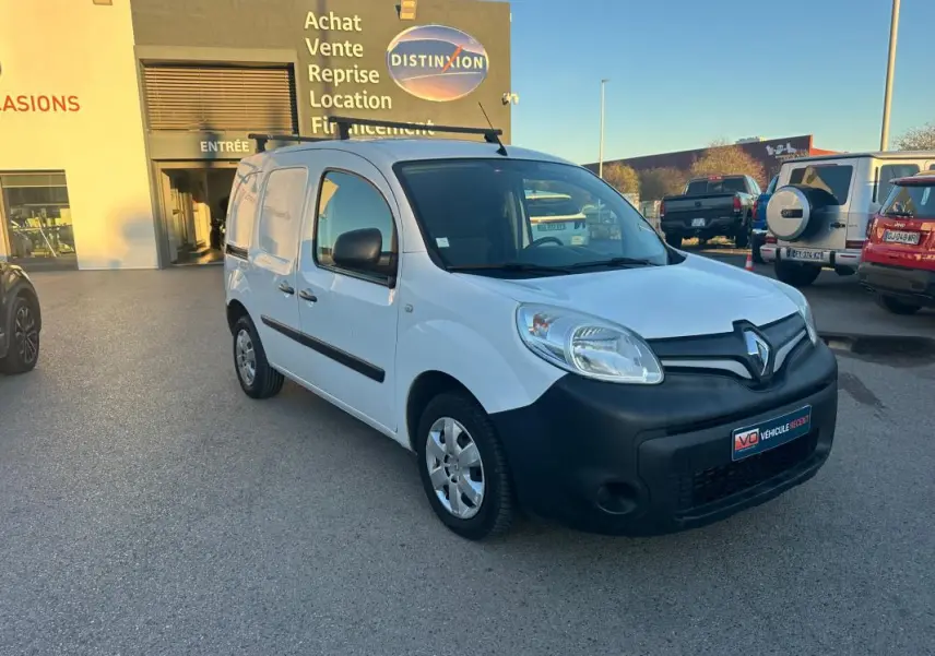 Renault Kangoo Express blanc en 3/4 avant droit avec pare-chocs noir et porte latérale visible sur parking.