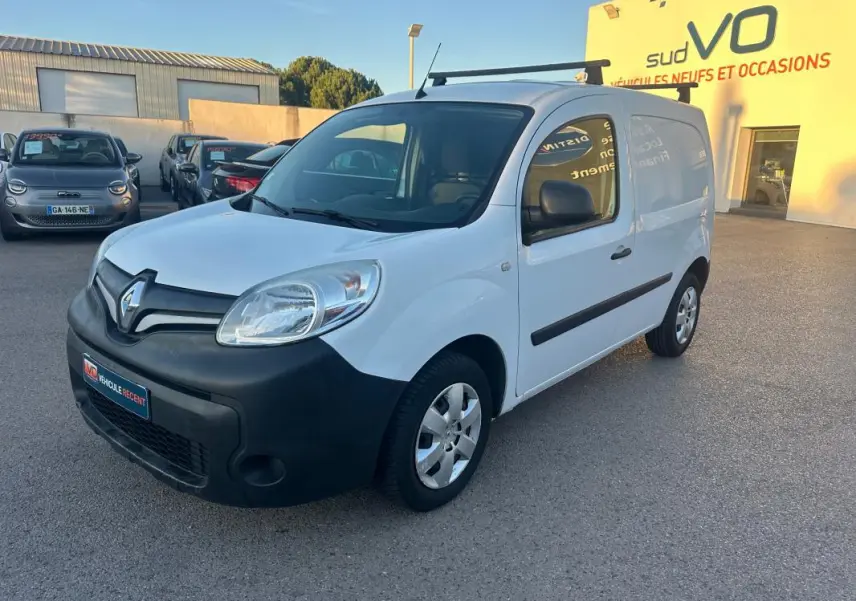 Renault Kangoo Express blanc en 3/4 avant droit, avec pare-chocs noir et porte latérale visible, stationné en extérieur.