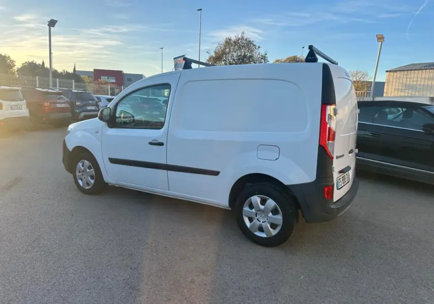 Renault Kangoo Express blanc vu de côté gauche en 3/4 arrière, avec porte latérale et barres de toit noires.
