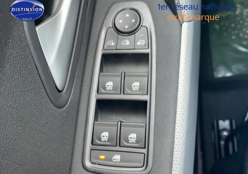 Gros plan sur les commandes des vitres électriques côté conducteur du Dacia Duster 2026, intérieur noir et gris.