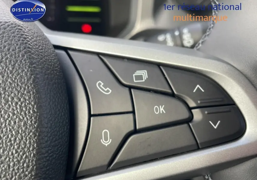 Gros plan sur les commandes multifonctions noires du volant du Dacia Duster 2026, finition Journey vert cèdre.