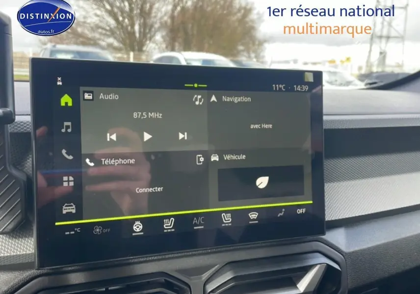 Écran tactile central du tableau de bord du Dacia Duster 2026 avec commandes audio et navigation visibles.