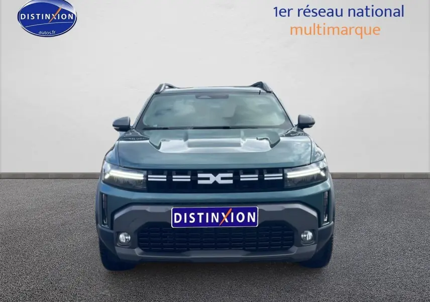 Vue frontale d'un Dacia Duster 1.2 mild hybrid 140 Journey vert cèdre avec calandre noire et phares LED allumés.