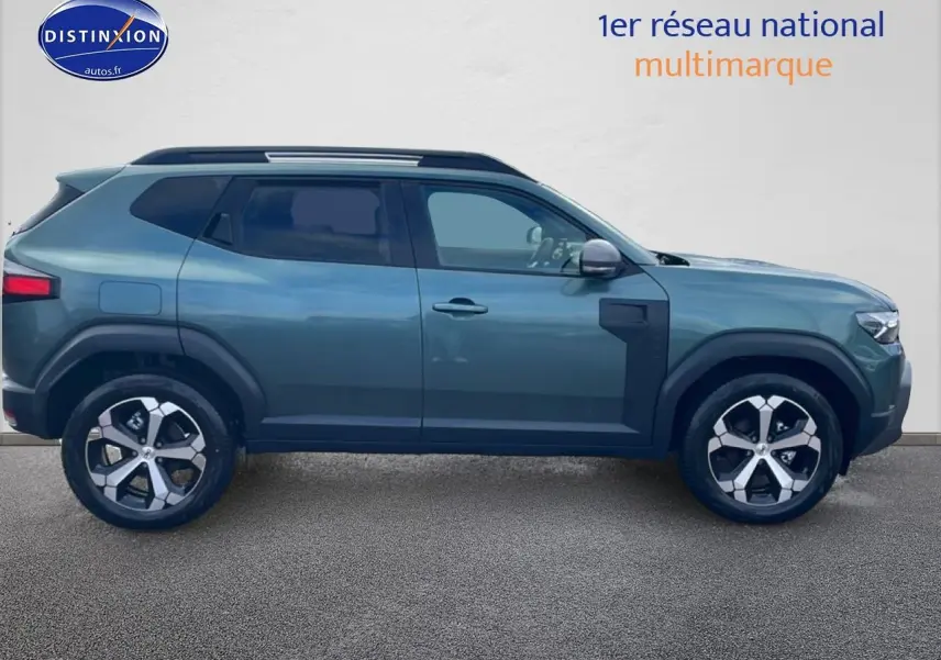 Profil droit du Dacia Duster 2026 vert cèdre avec jantes alu et barres de toit visibles sur fond neutre.