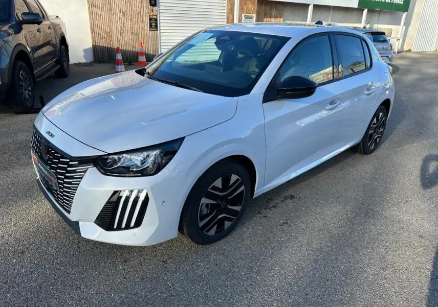 Peugeot 208 Hybrid blanc vue 3/4 avant droit, jantes alliage noires et calandre distinctive en extérieur.