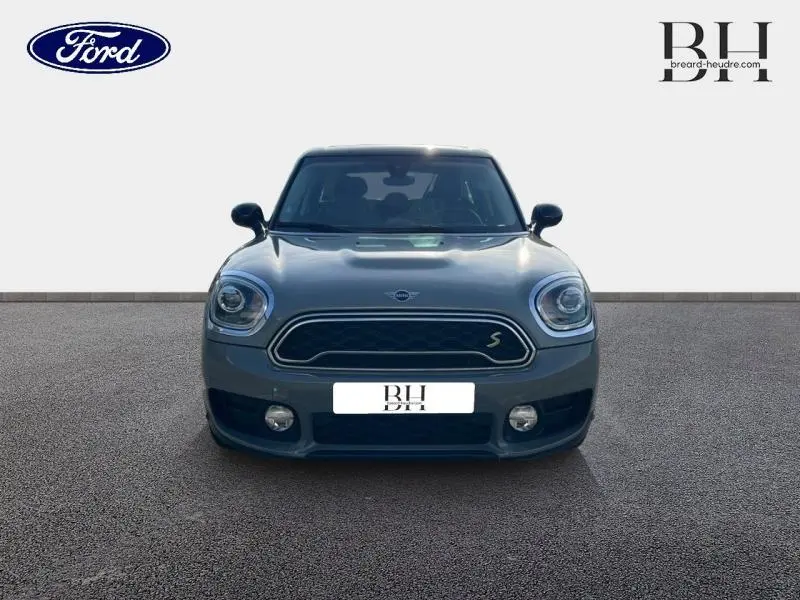 Vue de face d'une MINI Countryman Cooper SE Moonwalk Grey avec calandre chromée et toit panoramique visible.