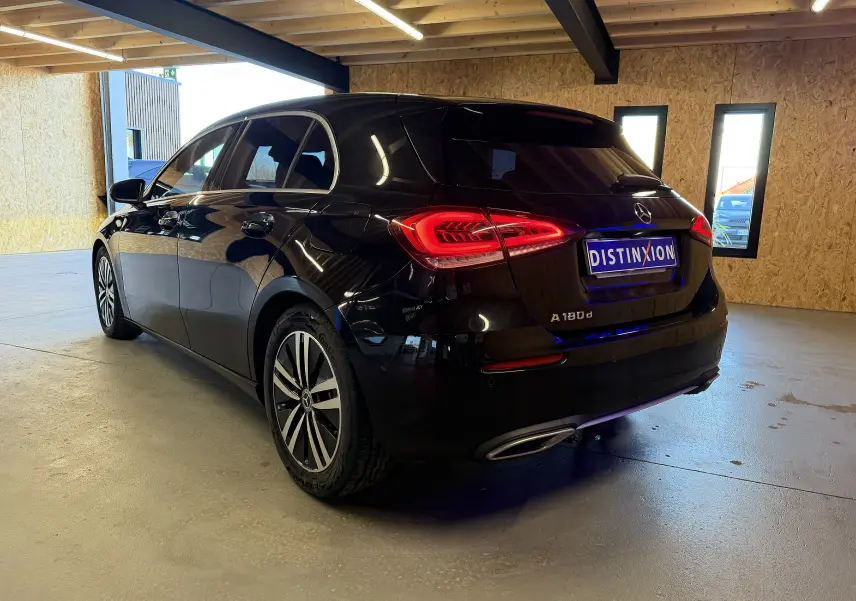 Vue 3/4 arrière droite d'une Mercedes Classe A noire avec feux LED allumés et sorties d'échappement chromées en intérieur.