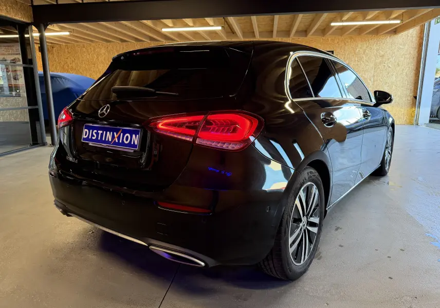 Vue 3/4 arrière droite d'une Mercedes Classe A noire avec feux LED et jantes alliage dans un garage.