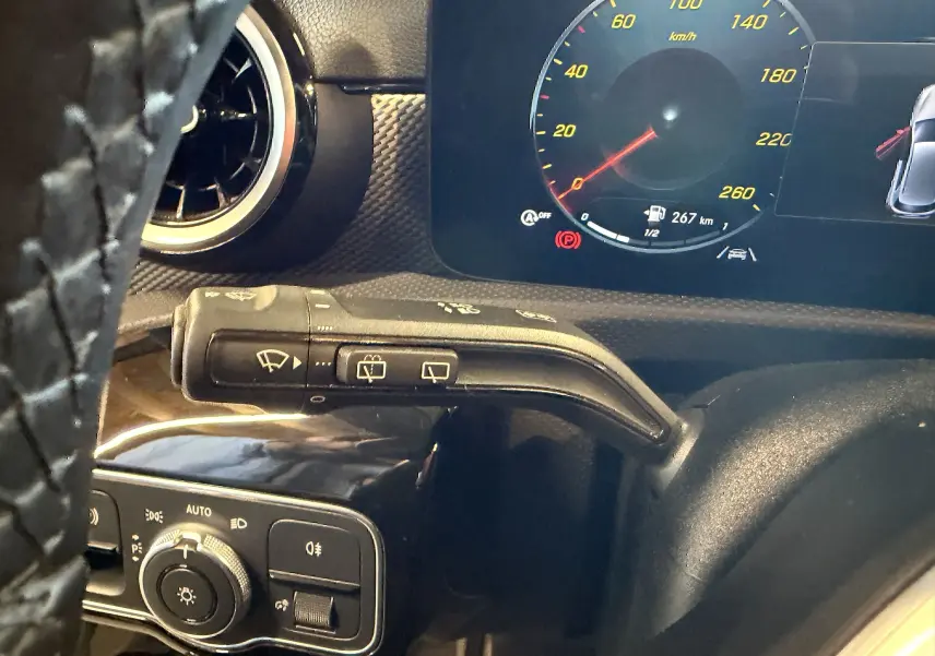 Gros plan intérieur sur le commodo d’essuie-glace et tableau de bord numérique d’une Mercedes Classe A noire 2022.