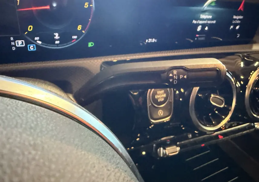 Gros plan intérieur sur le tableau de bord noir de la Mercedes Classe A, avec démarrage sans clé et levier de vitesses digital.