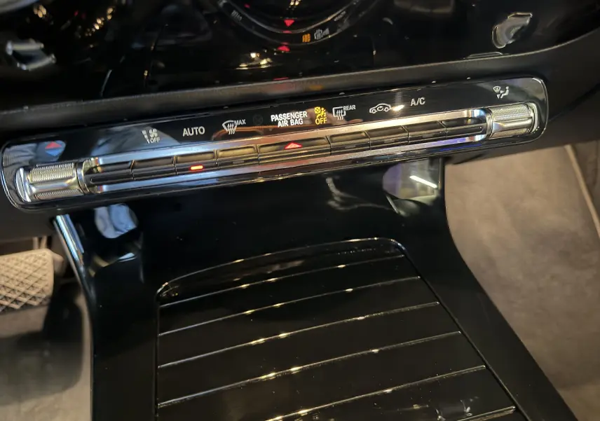 Vue rapprochée du panneau de commande de climatisation noir brillant dans l’habitacle d’une Mercedes Classe A 2022.