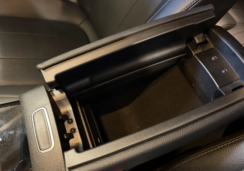 Vue rapprochée de l'accoudoir central avant noir ouvert de la Mercedes Classe A 2022, intérieur cuir noir.