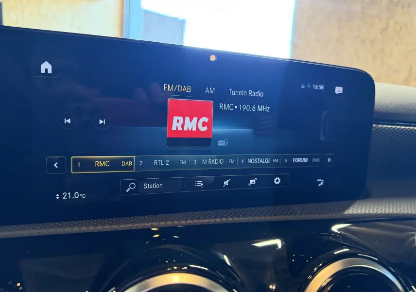 Écran tactile central de la Mercedes Classe A 2022 affichant la radio numérique RMC à 21°C, intérieur noir.