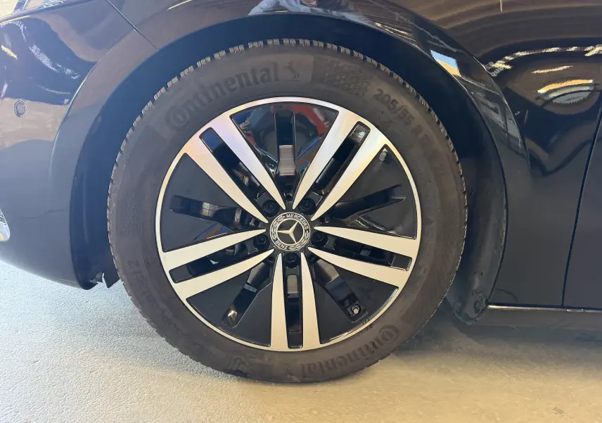 Gros plan sur la jante alu noire et argentée d'une Mercedes Classe A noire, côté avant droit.