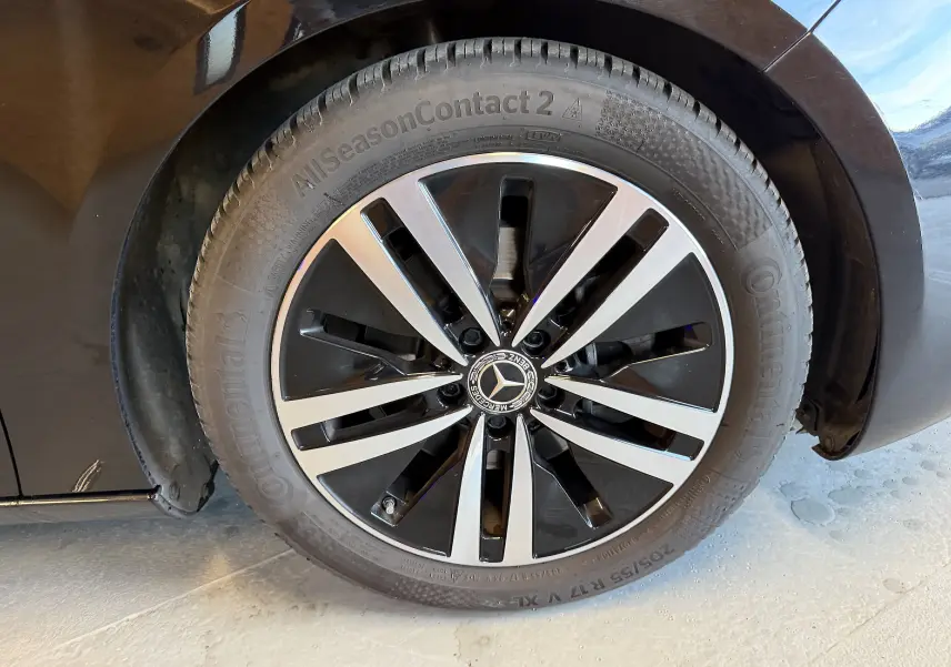 Gros plan sur la jante alu bicolore noire et argentée d'une Mercedes Classe A noire, avec pneu Continental visible.