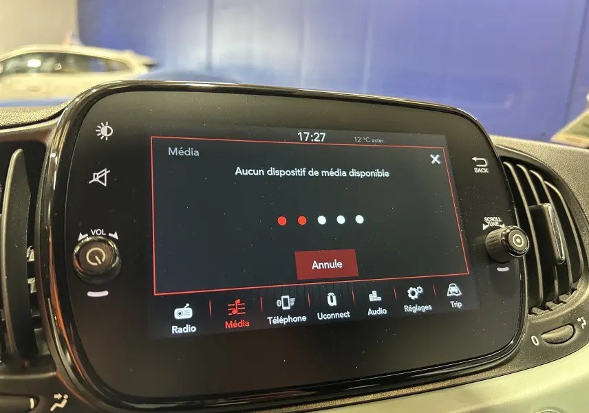 Écran tactile central de la Fiat 500 2023 affichant un message "Aucun dispositif de média disponible" en intérieur.
