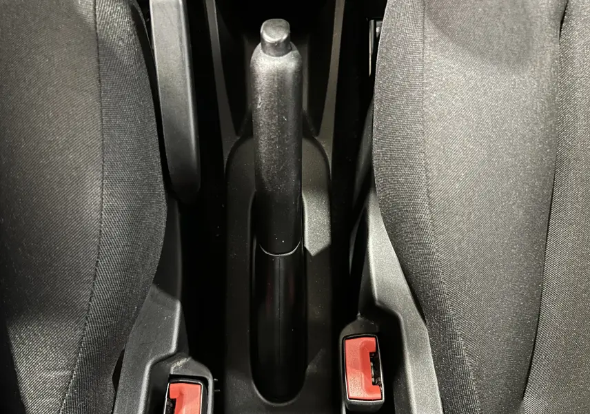 Vue plongeante sur le frein à main et les ceintures de sécurité entre les sièges avant en tissu gris de la Fiat 500.