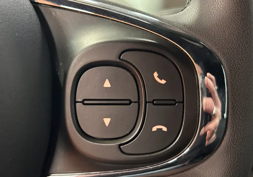 Gros plan sur les boutons de commande d’appel au volant d’une FIAT 500 2023, finition Rugiada Green.