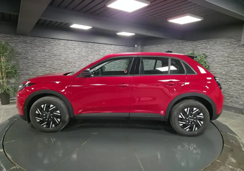 Vue de profil côté gauche du FIAT 600 1.2 Hybrid rouge avec jantes acier bicolores et coques de rétroviseurs noires.