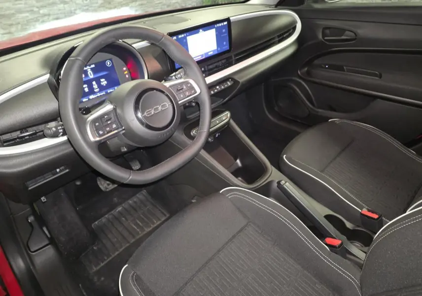 Intérieur noir de la FIAT 600 1.2 Hybrid 2024 vu côté conducteur, avec volant 600 et écran tactile central.