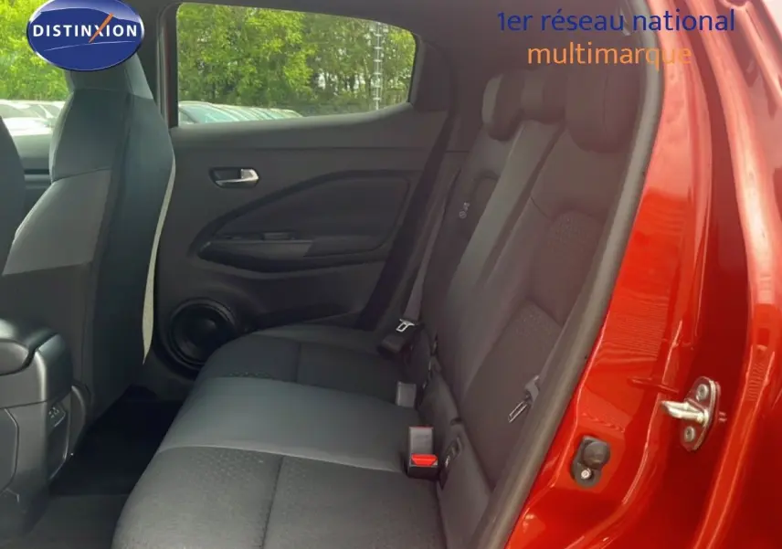 Vue intérieure côté droit des sièges arrière noirs du Nissan Juke rouge Fuji Metal 2024 avec porte ouverte.