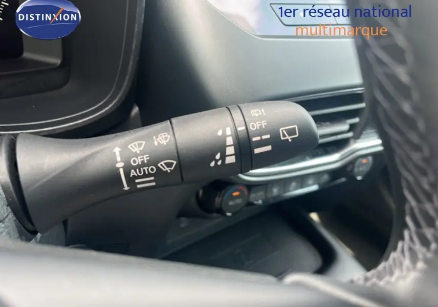Gros plan sur la commande des essuie-glaces du Nissan Juke rouge Fuji Metal 2024, intérieur noir avec volant cuir.