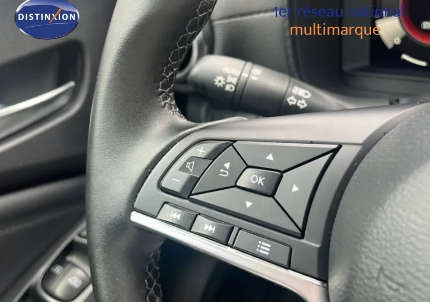 Gros plan sur les commandes au volant d’un Nissan Juke 2024, finition N-Connecta, intérieur noir.