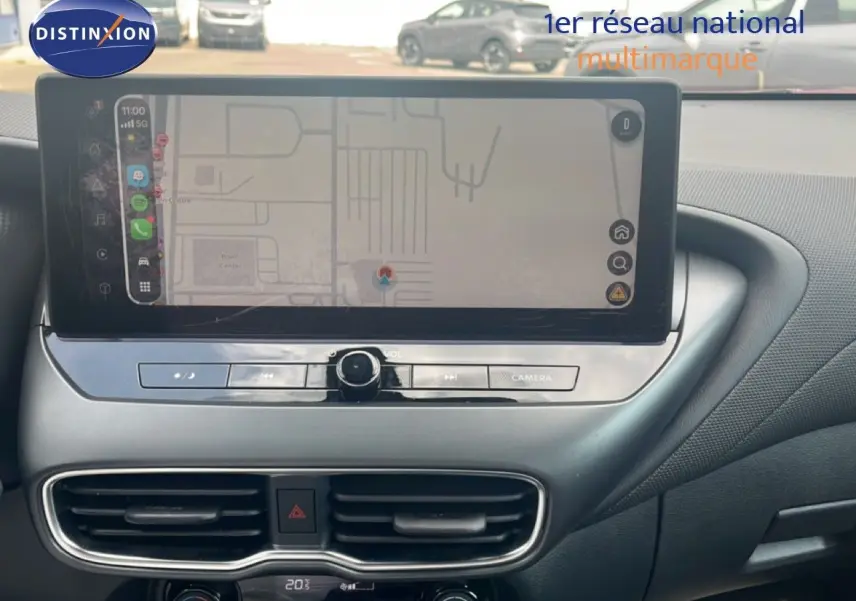 Vue rapprochée de l’écran tactile et de la console centrale du Nissan Juke rouge Fuji Metal 2024, avec commandes climatisation et navigation.