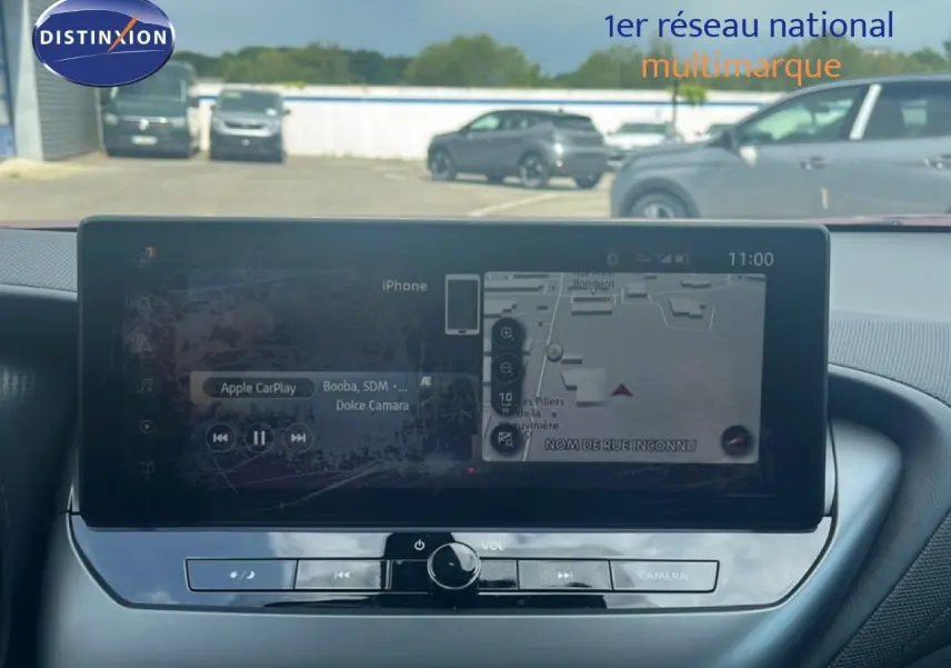 Vue intérieure centrée sur l'écran tactile du tableau de bord du Nissan Juke 2024, affichant navigation et Apple CarPlay.