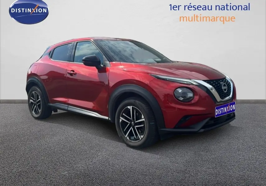 Nissan Juke rouge Fuji Metal en 3/4 avant droit, avec jantes noires et détails chromés visibles.