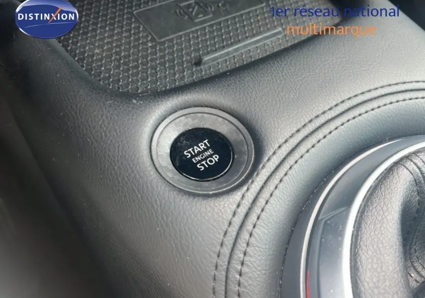 Gros plan sur le levier de vitesses en cuir noir de la Nissan Juke rouge Fuji Metal, version 2024 DIG-T 114CH N-Connecta.