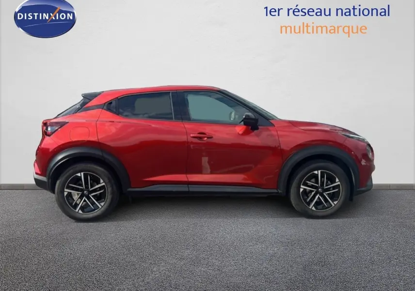 Vue latérale droite d'un Nissan Juke 2024 rouge Fuji Metal avec jantes alliage noires et toit noir contrasté.