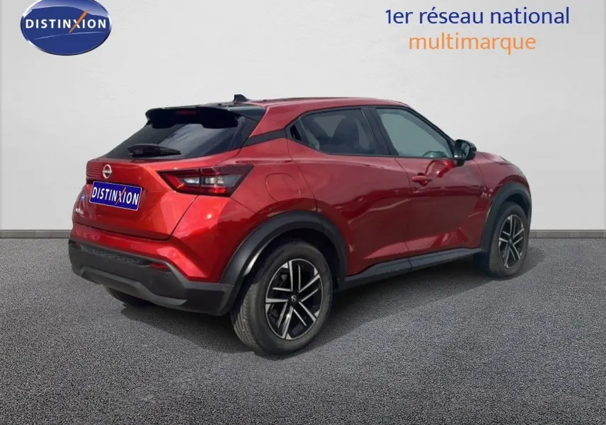 Nissan Juke rouge Fuji Metal en 3/4 arrière droit, avec jantes noires et toit noir contrasté.