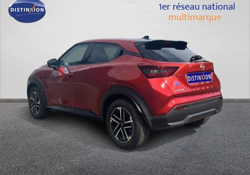 Vue 3/4 arrière droite d'un Nissan Juke 2024 rouge Fuji Metal avec jantes alliage et toit noir.