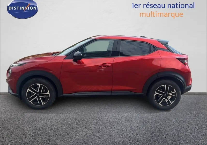 Profil droit du Nissan Juke 2024 rouge Fuji Metal avec jantes alliage et toit noir contrasté.