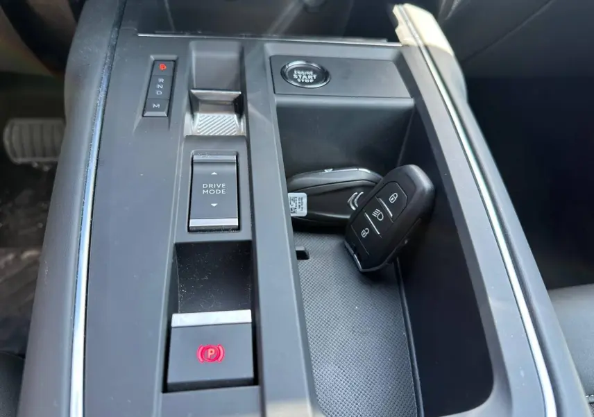 Vue rapprochée de la console centrale noire du Citroën C5 Aircross 2025 avec clé et boutons de boîte automatique.