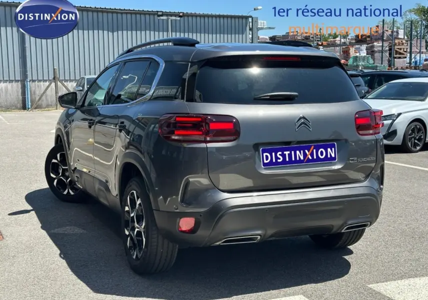 Vue 3/4 arrière droite d'un Citroën C5 Aircross gris Platinium avec feux LED et jantes alu noires.