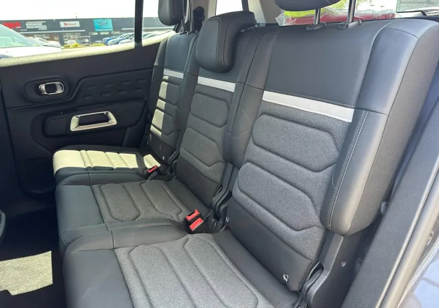 Vue latérale droite des trois sièges individuels gris foncé de la deuxième rangée du Citroën C5 Aircross 2025.