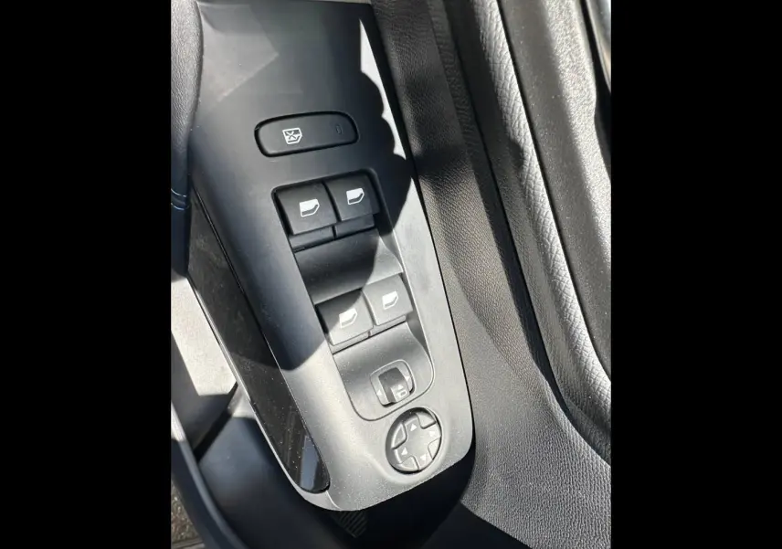 Gros plan sur les commandes des vitres et rétroviseurs côté conducteur du Citroën C5 Aircross 2025, intérieur noir.