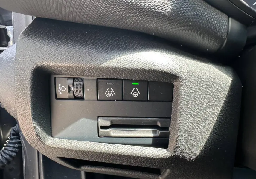 Gros plan sur les commandes d'assistance et réglage des phares côté gauche du tableau de bord du Citroën C5 Aircross gris Platinium.