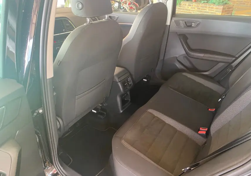 Vue intérieure arrière côté droit du SEAT Ateca noir 2019, montrant les sièges arrière et les dossiers avant en tissu noir.