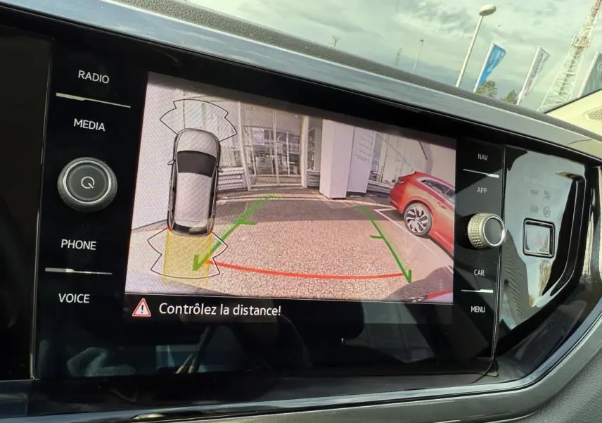 Écran central de la Volkswagen Polo 2025 montrant la caméra de recul avec vue arrière et guidage de trajectoire.