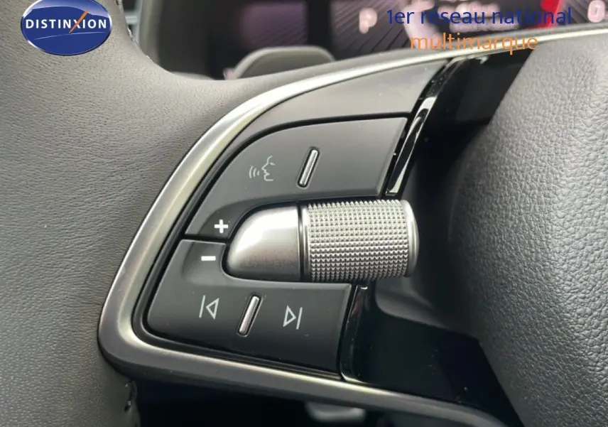 Gros plan sur les commandes au volant d’un Skoda Kamiq 2025 noir magique métal, mettant en valeur la molette et les boutons multifonctions.