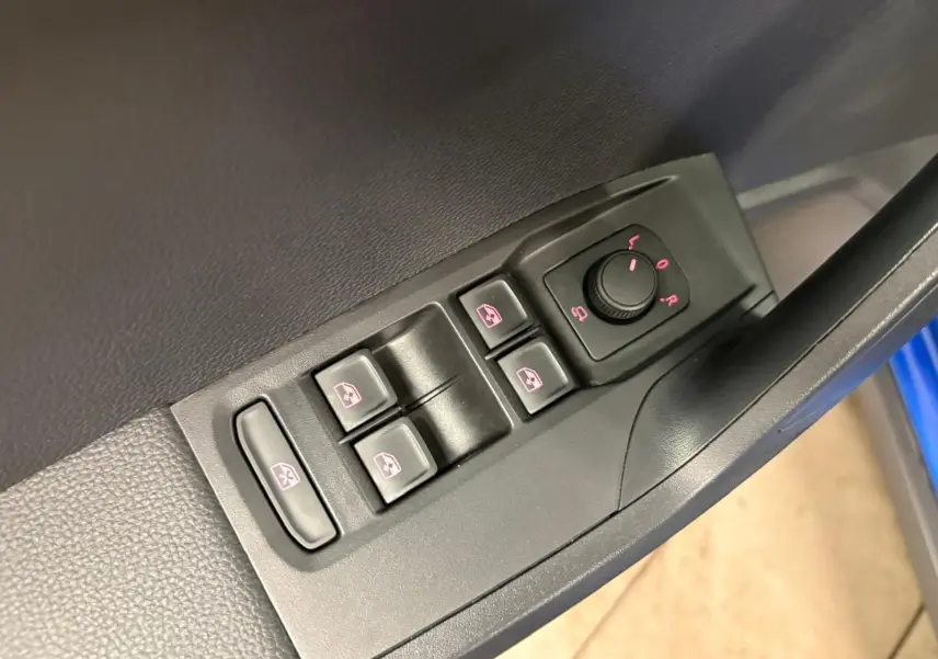 Gros plan sur les commandes des vitres et réglages des rétroviseurs côté conducteur du SEAT Arona Bleu Saphir.