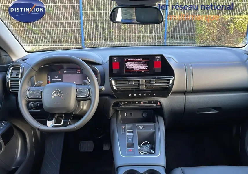 Vue intérieure avant du Citroën C5 Aircross 2025 noir, montrant le tableau de bord et le volant multifonction.