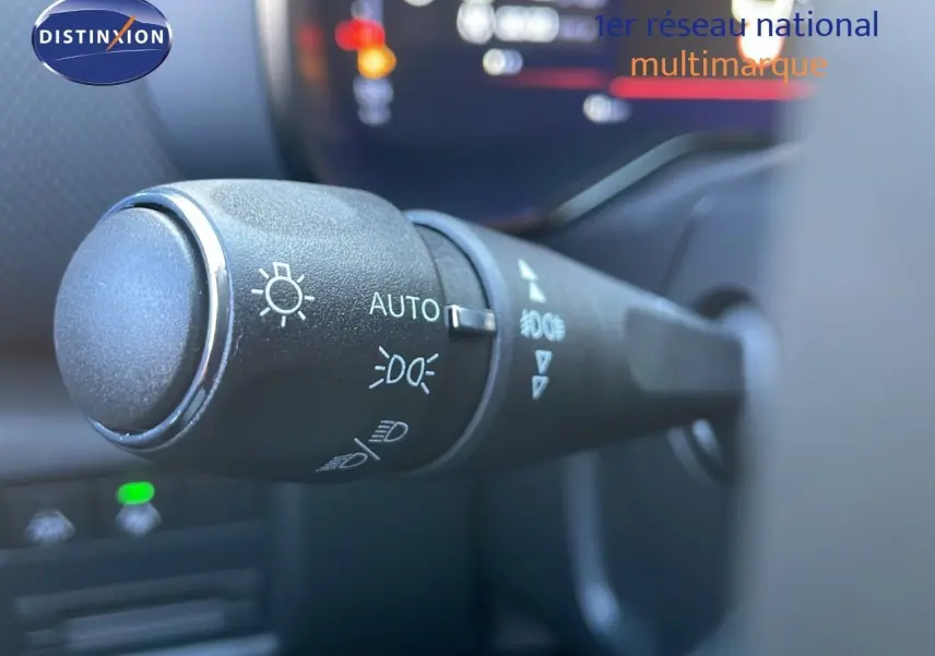 Gros plan sur la commande des feux du Citroën C5 Aircross noir Perla Metal, intérieur avec tableau de bord flou.